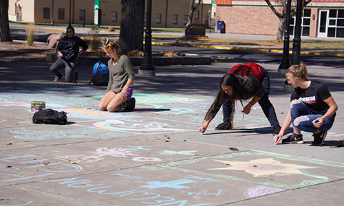 students drawing with chalk on the ground